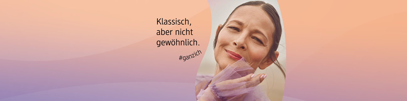 Frau hält zarten lilafarbenen Tüllstoff vor sich, trägt klassische Kleidung, vor unscharfem Hintergrund mit dem Text ‚Klassisch, aber nicht gewöhnlich. #ganzich auf pastellfarbenem Hintergrund